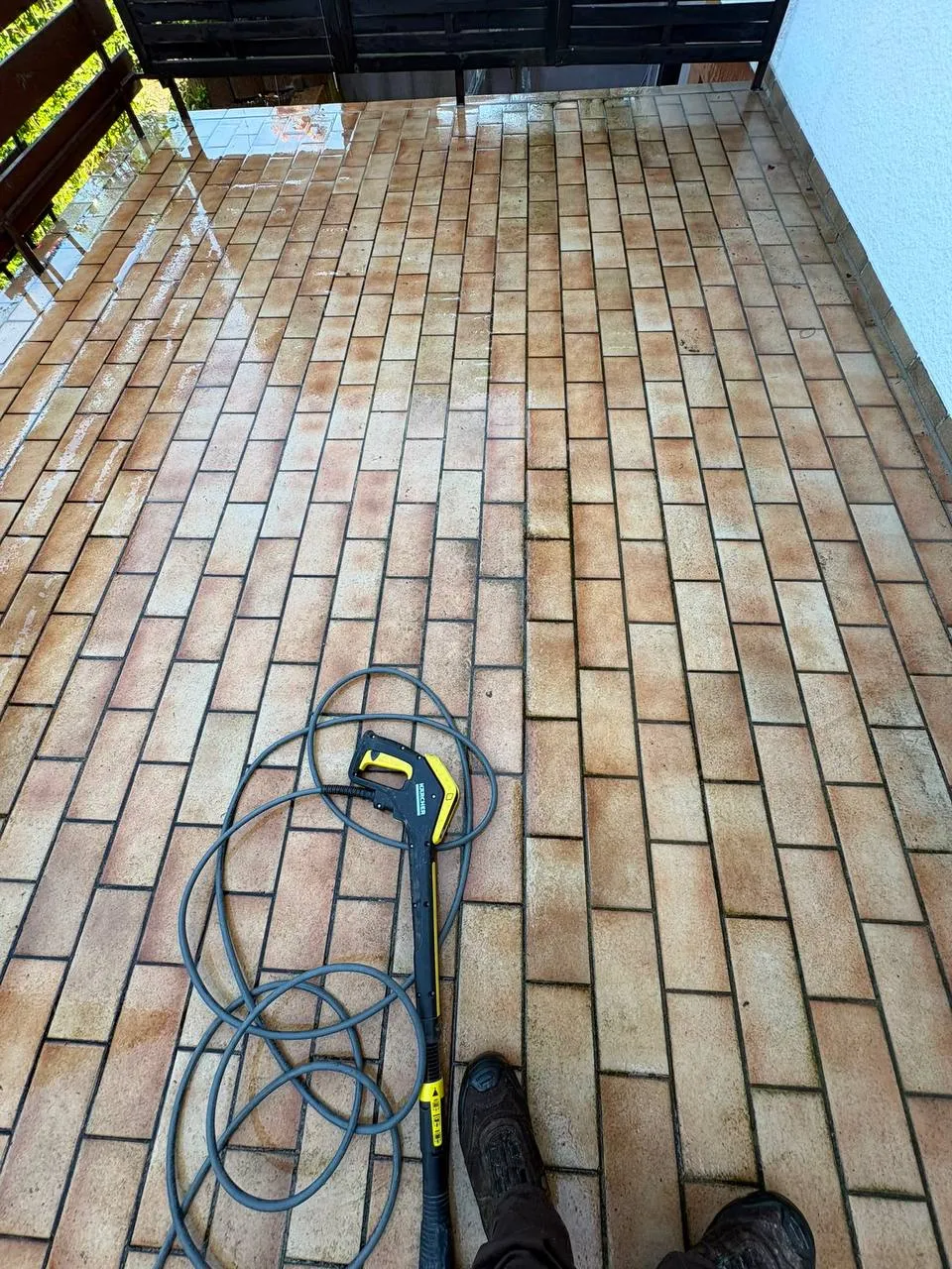 Terrasse zur Hälfte mit dem Hochdruckreiniger gereinigt